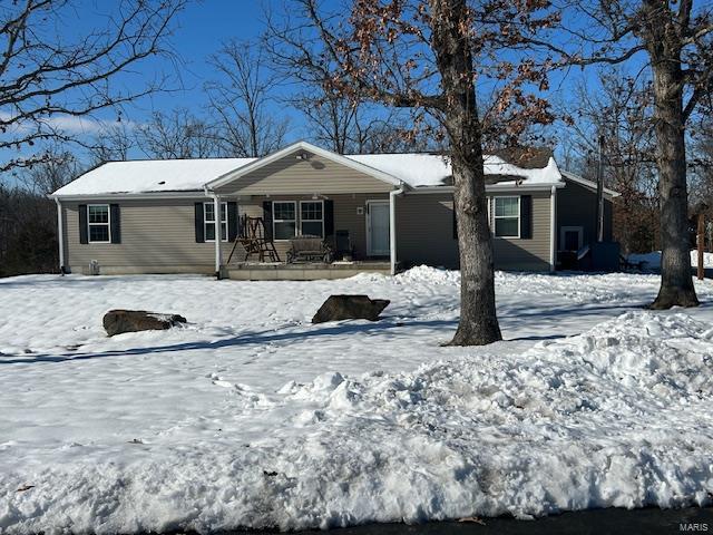 snow covered property with a porch