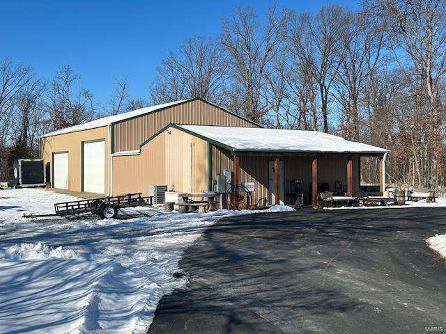 snow covered structure featuring a garage