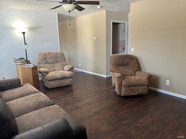 living room with ceiling fan, a textured ceiling, and dark hardwood / wood-style floors