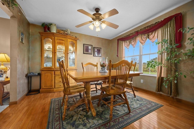 dining area with light hardwood / wood-style flooring and ceiling fan