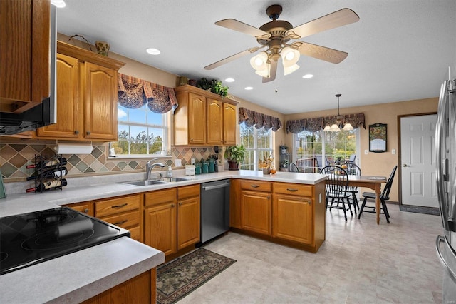 kitchen with sink, decorative light fixtures, kitchen peninsula, stainless steel appliances, and decorative backsplash