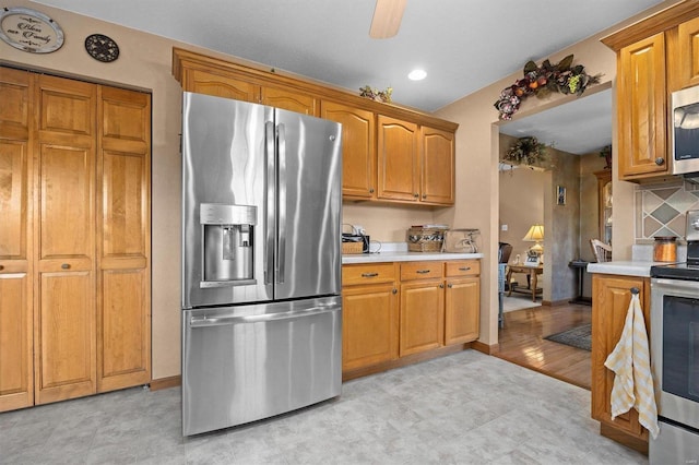 kitchen featuring stainless steel appliances, backsplash, and ceiling fan