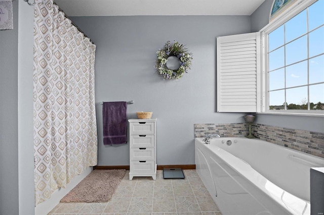 bathroom with a healthy amount of sunlight, a washtub, and tile patterned floors