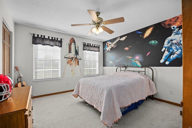 carpeted bedroom featuring ceiling fan and a textured ceiling