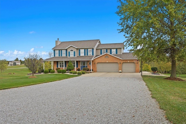 view of front of property featuring a garage, a front lawn, and covered porch