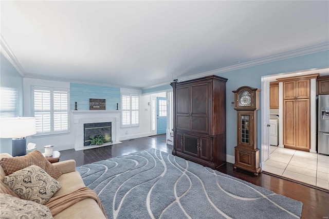 living room with a large fireplace, ornamental molding, and dark hardwood / wood-style flooring