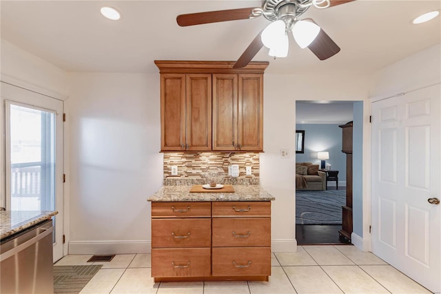 kitchen featuring light stone counters, dishwasher, decorative backsplash, light tile patterned flooring, and ceiling fan