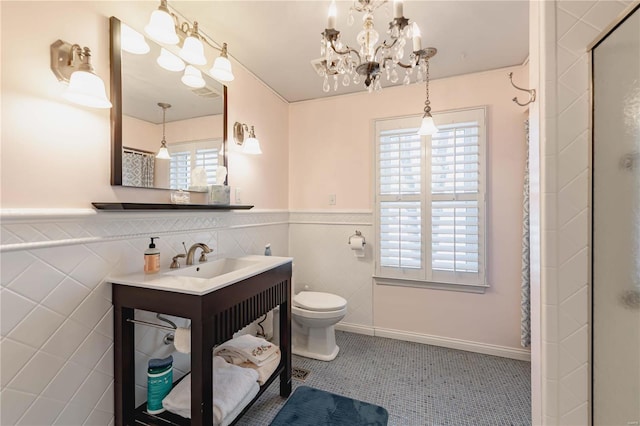 bathroom featuring toilet, walk in shower, vanity, tile patterned floors, and an inviting chandelier