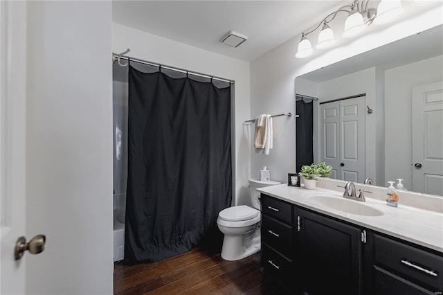 full bathroom featuring toilet, shower / bath combo with shower curtain, wood-type flooring, and vanity