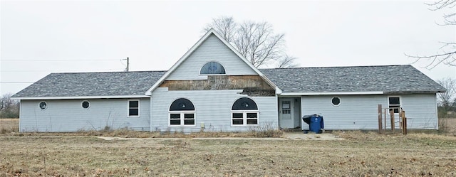 rear view of property featuring a lawn