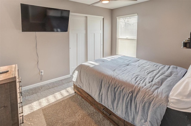 carpeted bedroom featuring ceiling fan and a closet