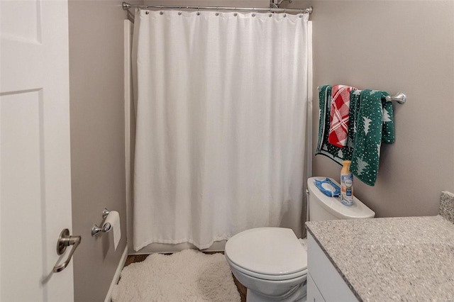 bathroom featuring a shower with curtain, vanity, and toilet