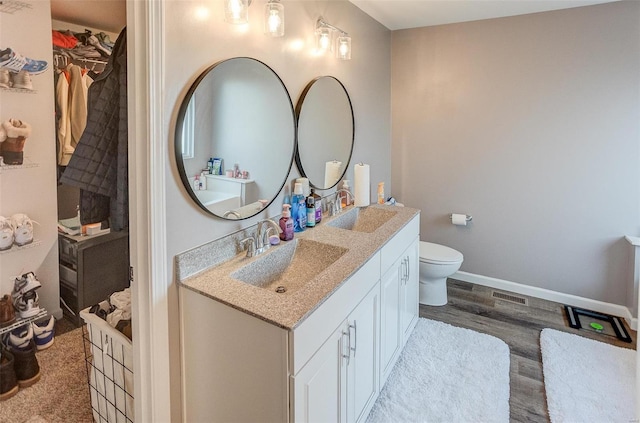 bathroom featuring hardwood / wood-style flooring, vanity, and toilet