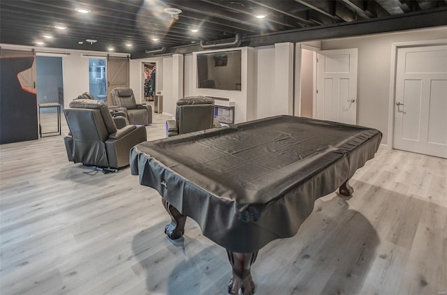 recreation room featuring a barn door, billiards, and light wood-type flooring