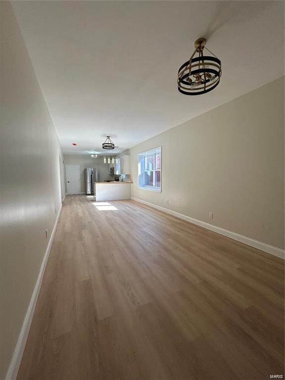 unfurnished living room featuring hardwood / wood-style floors and a notable chandelier