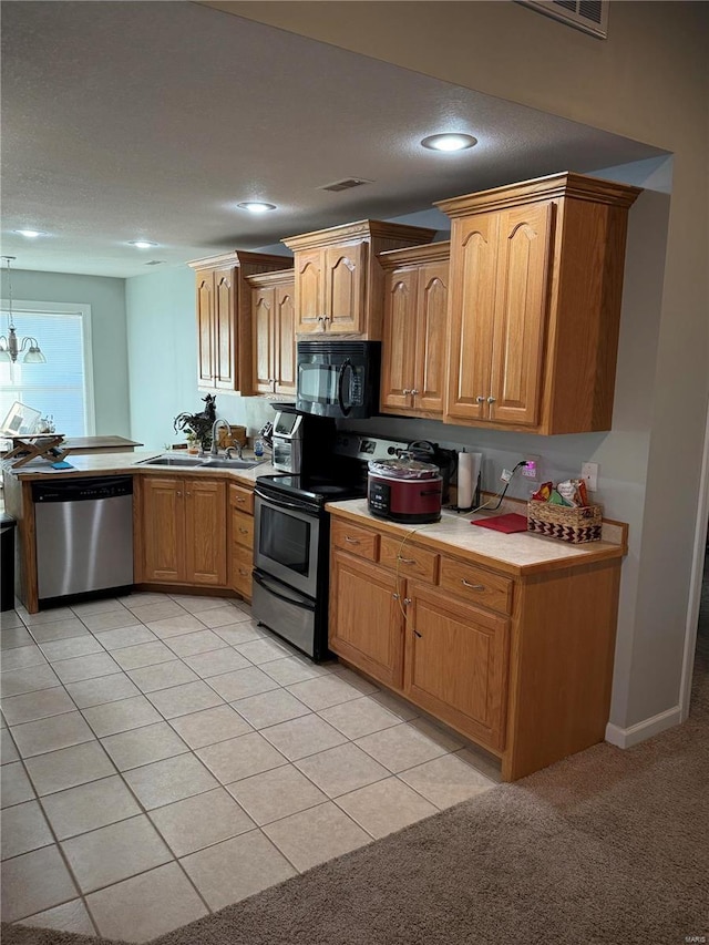 kitchen with sink, light tile patterned floors, appliances with stainless steel finishes, decorative light fixtures, and a chandelier