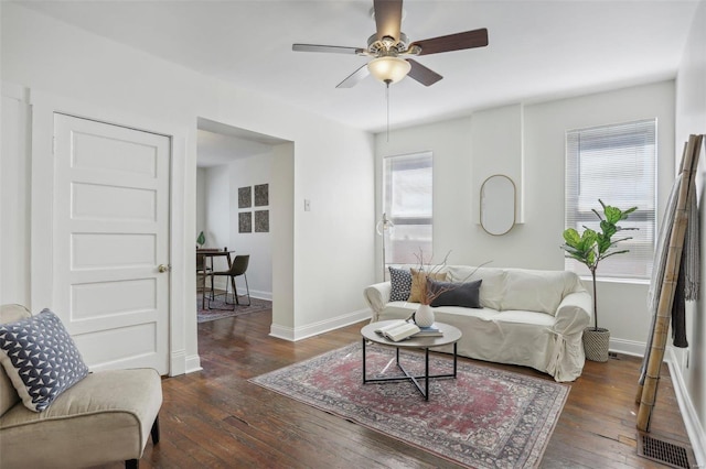 living room with ceiling fan and dark wood-type flooring