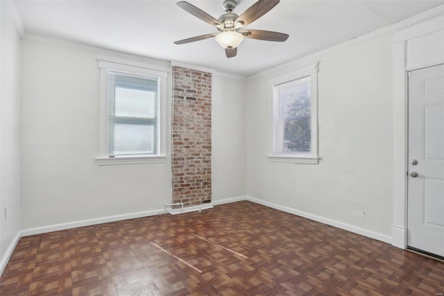 empty room featuring dark parquet floors, ceiling fan, and a wealth of natural light