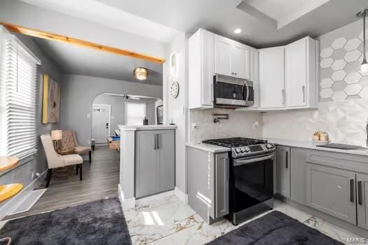 kitchen featuring gray cabinetry, sink, backsplash, and appliances with stainless steel finishes