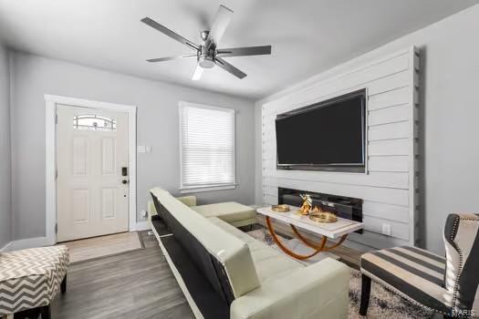 living room with dark hardwood / wood-style flooring and ceiling fan