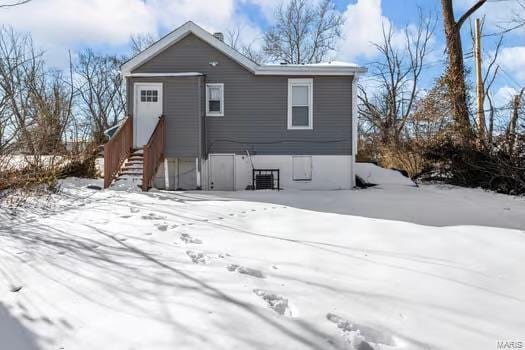 view of snow covered rear of property