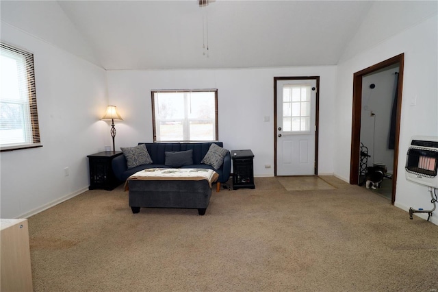 carpeted living room with vaulted ceiling, heating unit, and plenty of natural light