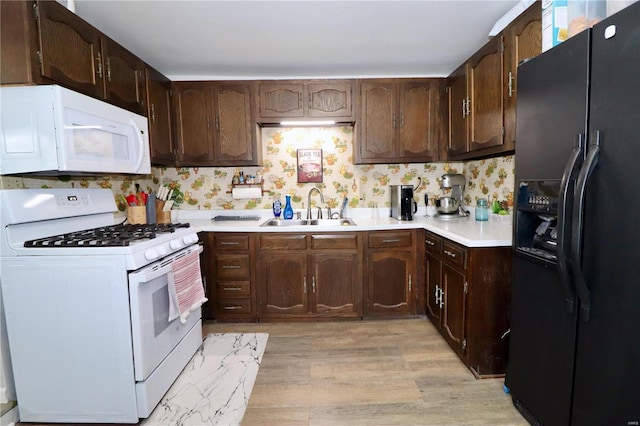 kitchen with white appliances, dark brown cabinetry, sink, light hardwood / wood-style flooring, and backsplash