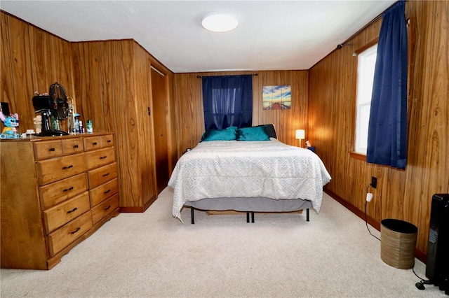 bedroom featuring wooden walls and light carpet