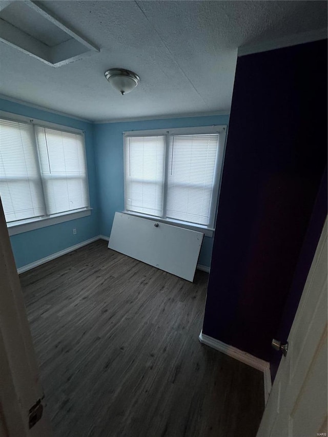 unfurnished room featuring dark hardwood / wood-style floors and a textured ceiling