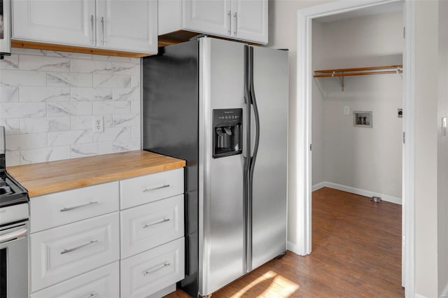 kitchen featuring hardwood / wood-style flooring, wooden counters, white cabinets, backsplash, and stainless steel appliances