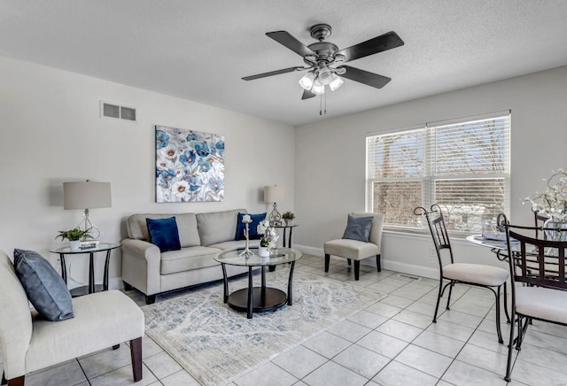 tiled living room with ceiling fan and a textured ceiling