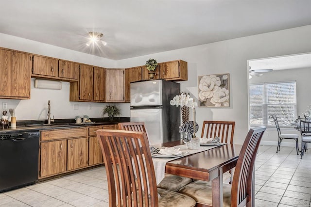 kitchen featuring sink, light tile patterned floors, stainless steel refrigerator, black dishwasher, and ceiling fan