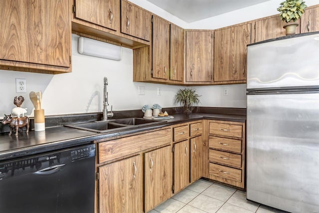 kitchen featuring stainless steel fridge, black dishwasher, sink, and light tile patterned floors