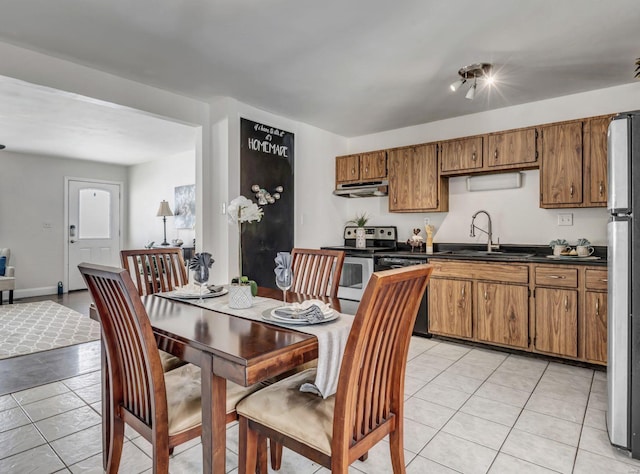 kitchen with stainless steel appliances, sink, and light tile patterned floors