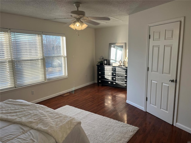 bedroom featuring ceiling fan, dark hardwood / wood-style flooring, and a textured ceiling