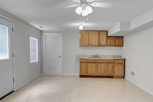 kitchen featuring ceiling fan, sink, and a textured ceiling