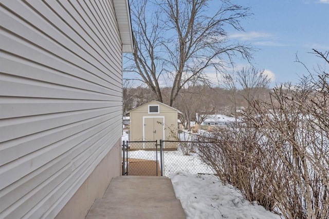 view of snowy exterior with a storage shed