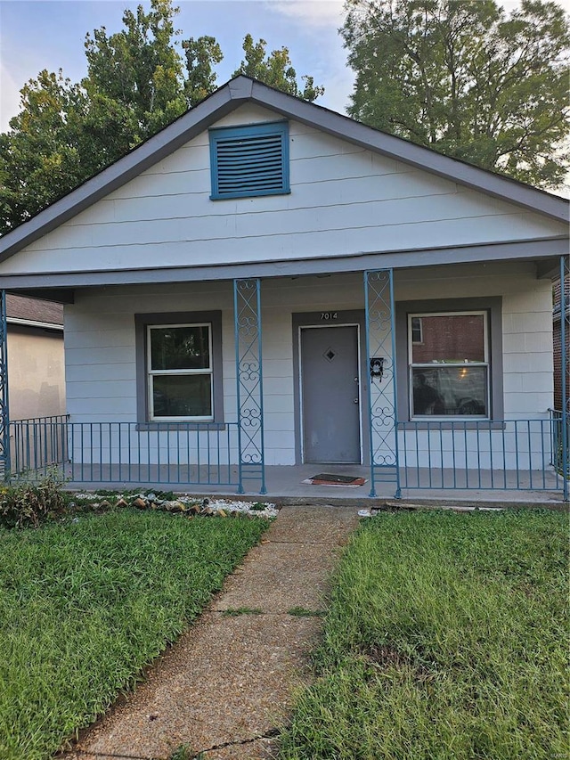 view of front of property featuring covered porch and a front lawn