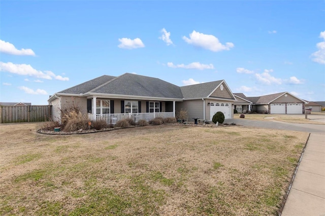 ranch-style house featuring a front yard, a garage, and covered porch