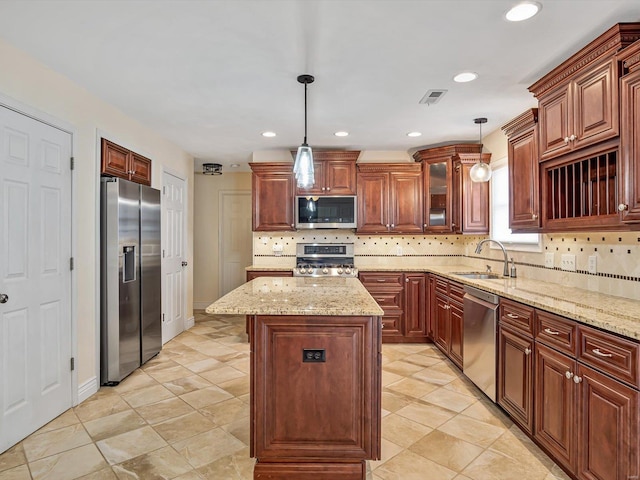 kitchen with pendant lighting, stainless steel appliances, tasteful backsplash, a kitchen island, and sink