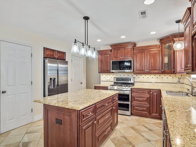 kitchen with sink, decorative light fixtures, a center island, and appliances with stainless steel finishes