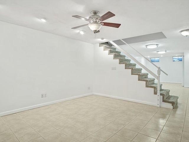 basement featuring ceiling fan and light tile patterned flooring