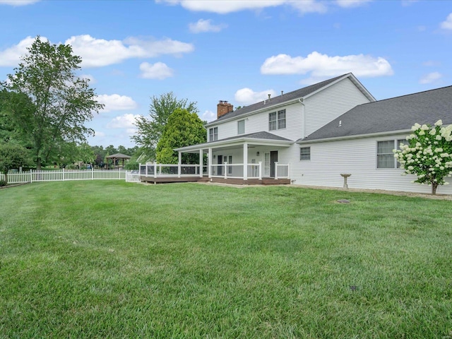 back of property featuring a deck and a yard