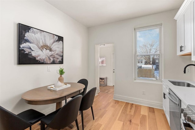 dining space featuring sink and light hardwood / wood-style floors