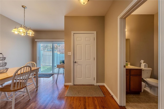 entryway with a chandelier and dark wood-type flooring