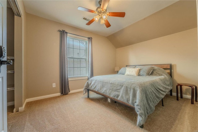 carpeted bedroom with ceiling fan and vaulted ceiling