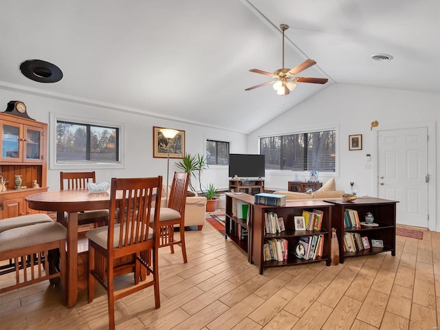 dining space featuring light wood-type flooring, ceiling fan, visible vents, and lofted ceiling