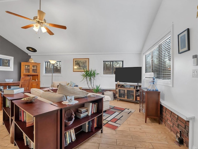 living area featuring light wood-type flooring, vaulted ceiling, and ceiling fan