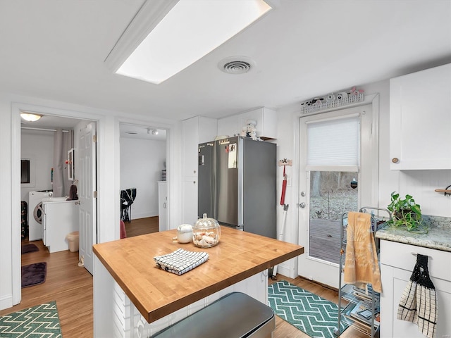 kitchen with visible vents, wood counters, light wood finished floors, and white cabinetry