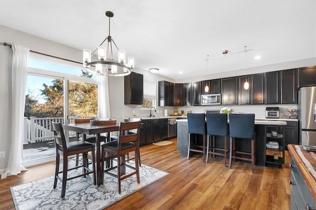 dining space featuring sink, hardwood / wood-style floors, and a chandelier